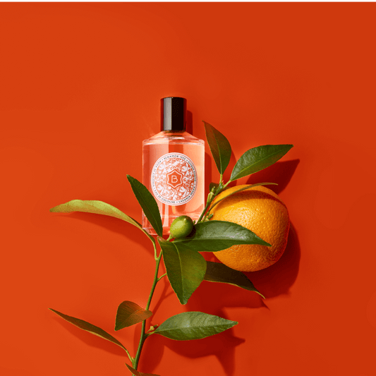 cologne bottle with orange tree branch